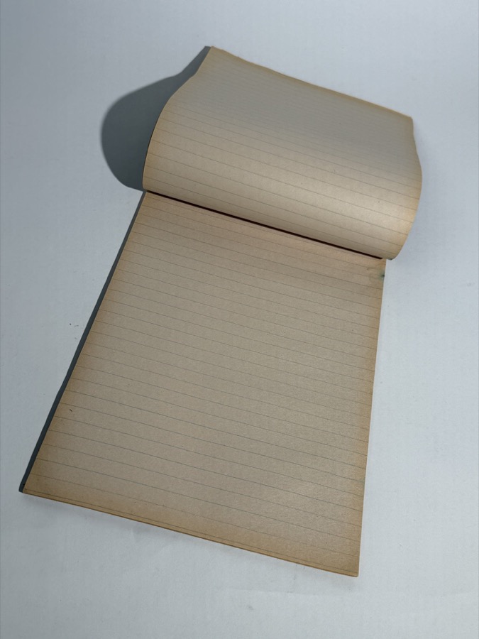 A well-worn Big Chief paper tablet, pages rolled over the top